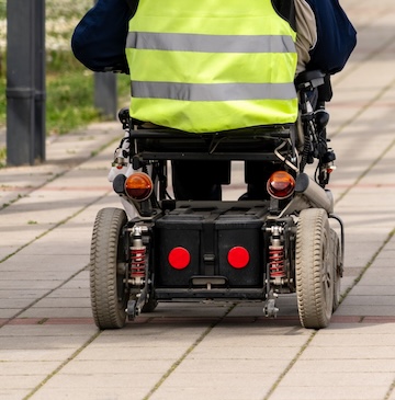 Electric wheelchair and accessible environment in the city. Mobility Scooter Stock Photo
